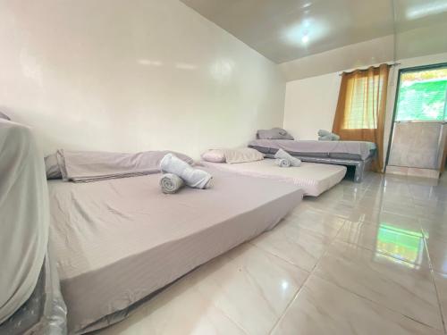 a room with three beds in it at Two-Storey House for Big Groups in Lapu Lapu City