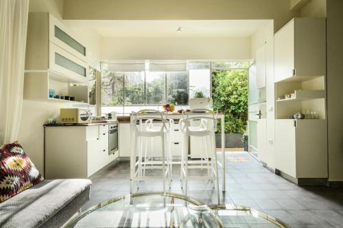 Serene Retreat with Lush Garden في تل أبيب: مطبخ مع بار فيه كراسي