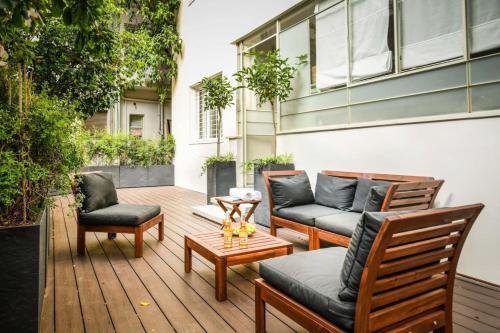 Serene Retreat with Lush Garden في تل أبيب: فناء مع كراسي وأريكة وطاولة