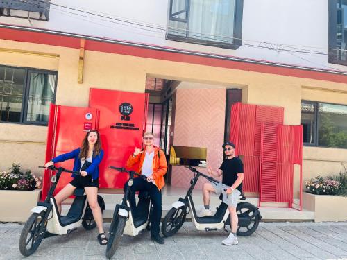 three people sitting on scooters in front of a building at Dali Upland International Youth Hostel, near the south gate of the ancient city ,5 mins walk to the old town, Close to Er Hai Lake, convenient payment and visa cards are accepted in Dali