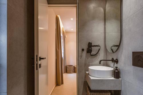 a bathroom with a sink and a mirror at Villa Cosmos by Villa Plus in Malia