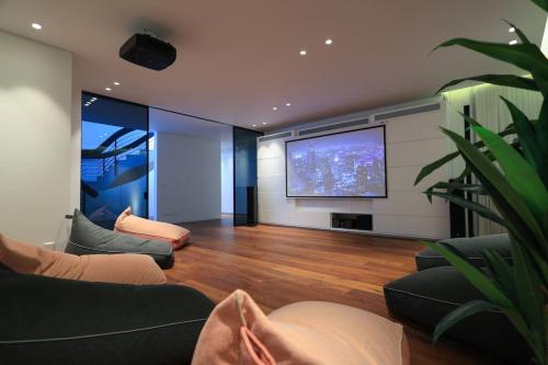 a living room with a flat screen tv and a couch at Breathtaking Villa w Pool & Sauna Near the Beach by Sea N' Rent in Herzelia 
