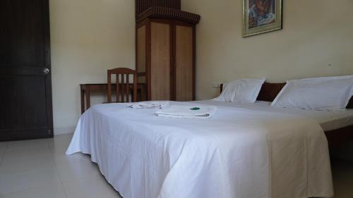 a bedroom with two beds with a white blanket at Candolim Beach Apartments Goa in Candolim