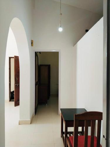 a dining room with a table and a hallway at Candolim Beach Apartments Goa in Candolim