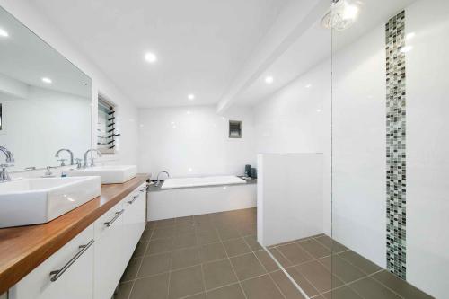 a white bathroom with two sinks and a shower at Lilies Lakeside Spa Villa - 2 Bedroom in Lovedale