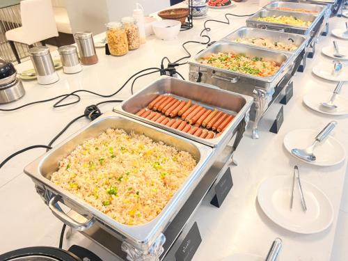 a buffet with several trays of food on a table at The Space Hotel Chiang Rai in Chiang Rai