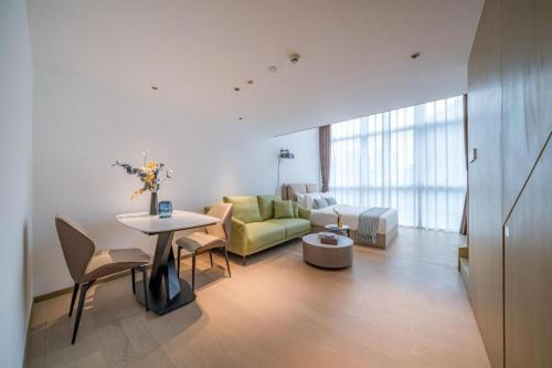 a living room with a couch and a table at F-TOWN Fangtang Hotel (Shenzhen Longgang Tian'an Digital City Huanggekeng Subway Station) in Shenzhen