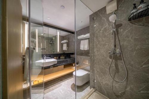 a bathroom with a shower and a toilet and a sink at F-TOWN Fangtang Hotel (Shenzhen Longgang Tian'an Digital City Huanggekeng Subway Station) in Shenzhen