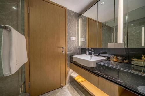 a bathroom with a sink and a mirror at F-TOWN Fangtang Hotel (Shenzhen Longgang Tian'an Digital City Huanggekeng Subway Station) in Shenzhen