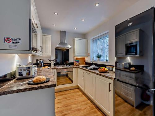 a kitchen with white cabinets and stainless steel appliances at 2 Bed in Filey 89281 in Hunmanby