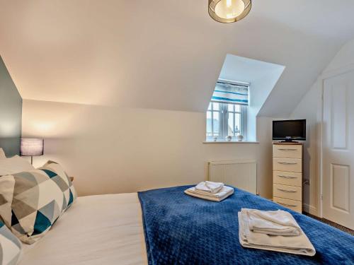 a bedroom with a bed and a tv and a window at 2 Bed in Filey 89281 in Hunmanby