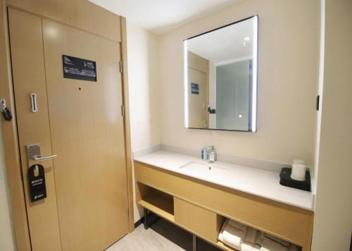 a bathroom with a sink and a mirror at City Comfort Inn Changsha Sifangping University of National Defense Science and Technology in Changsha