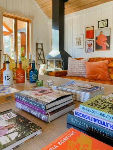a pile of books on a table in a living room at Spacious Farm By Åkulla Beech Forests in Tvååker