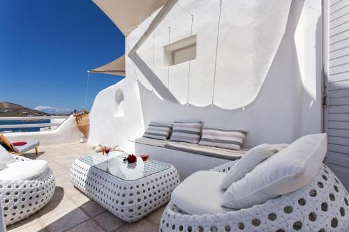 a balcony with white furniture and a view of the ocean at Yades - All Sea VIew Suites - Adults only in Naousa