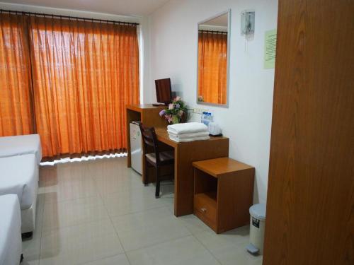 a bathroom with a desk with a sink and a toilet at Phetsuwan Hotel in Phetchabun