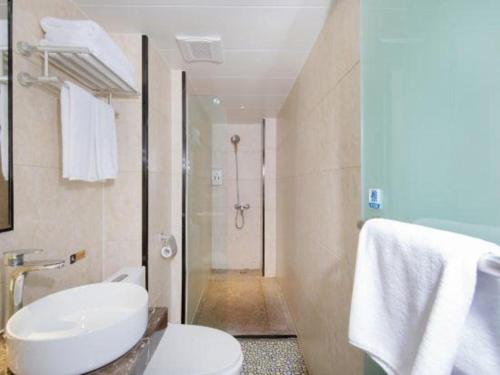 a bathroom with a toilet and a sink and a shower at Wenxing Hotel Guangzhou Huajing Xincheng Branch in Guangzhou