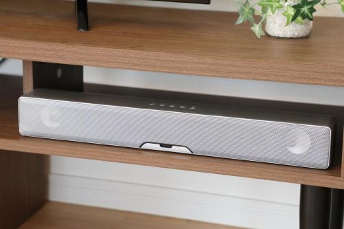 a speaker is sitting on a wooden shelf at blue sea and house in Nanjo