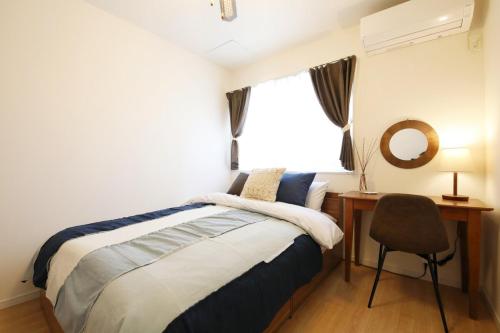 a bedroom with a bed and a desk and a mirror at blue sea and house in Nanjo