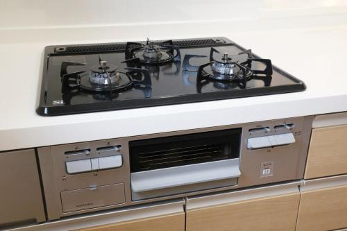 a stove top with three pots on top of it at blue sea and house in Nanjo