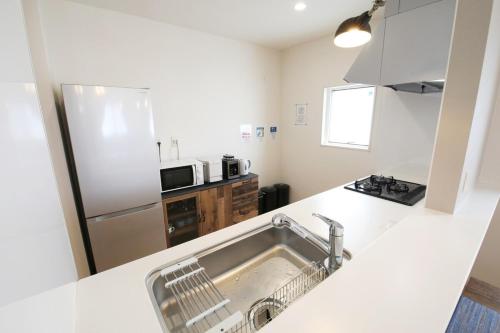 a kitchen with a sink and a refrigerator at blue sea and house in Nanjo