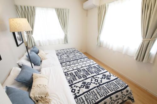 a bedroom with two beds and a window at blue sea and house in Nanjo
