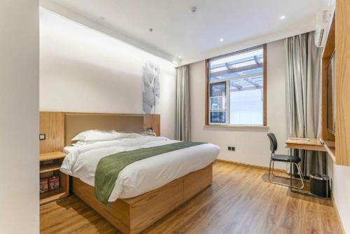 a bedroom with a large bed and a window at Green Tree Inn Tianjin Jinnan Linshijun University of Finance and Economics in Tianjin