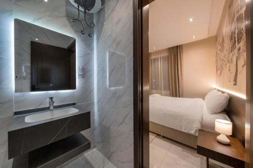 a bathroom with a sink and a shower with a television at Saden Albwadi in Jeddah