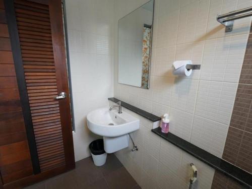 un bagno con lavandino e specchio di RoomQuest Chiang Mai Tha Sala a Chiang Mai