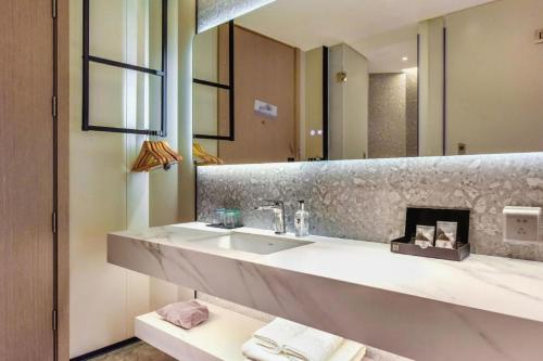 a bathroom with a sink and a large mirror at Borrman Hotel Chongqing Bishan Central Street in Chongqing