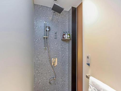a shower with a shower head in a bathroom at Borrman Hotel Chongqing Bishan Central Street in Chongqing