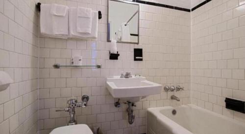a white bathroom with a sink and a toilet at Hotel Harrington in Washington