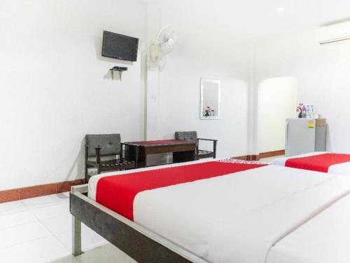 ein Schlafzimmer mit einem Bett, einem Schreibtisch und einem Fernseher in der Unterkunft OYO 627 Sai Thai Garden Home Travel in Ban Klang