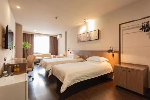 une chambre d'hôtel avec deux lits et un canapé dans l'établissement Jinjiang Inn Select Wuhan Xinhua Road Xiehe Hospital, à Wuhan
