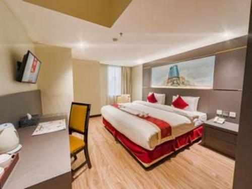 a hotel room with a large bed and a desk at Hermes Palace Hotel Medan in Medan