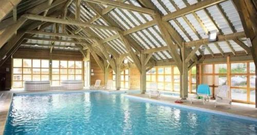une grande piscine intérieure avec un bâtiment avec des fenêtres dans l'établissement Apartement Les Fermes de St Sorlin F204, à Saint-Sorlin-dʼArves