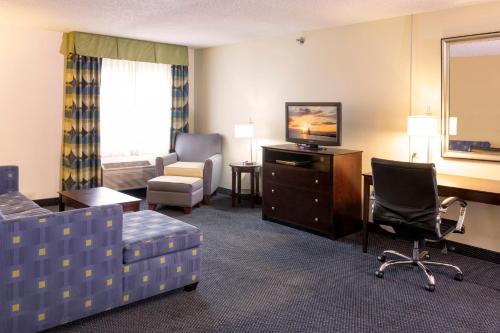 a hotel room with a couch chair and a television at Holiday Inn Express Hotel & Suites-Saint Joseph by IHG in Saint Joseph