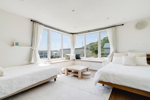 two beds in a white room with windows at Perfect Winter Villa Retreat - 14 minutes to downtown in Sapporo