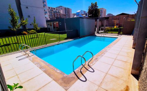a swimming pool with blue water in a city at El lugar que buscas en Ñuñoa 5to Piso in Santiago