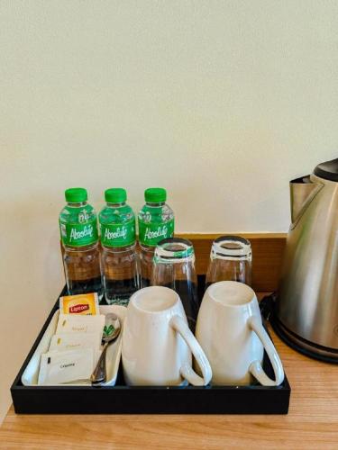 a tray with bottles of water and mugs on a table at Awesome Hotel in San Juan