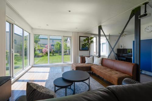 a living room with a couch and a table at Perfect Winter Villa Retreat - 14 minutes to downtown in Sapporo