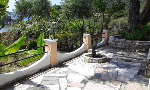 a garden with a fence and a small tree at Akis Apartments Kontogialos-Pelekas in Pelekas