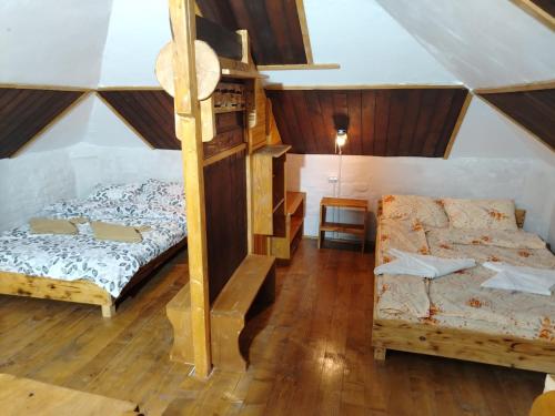 a room with a loft bed and a bed and a couch at Cabana Poiana Florica in Ciucea