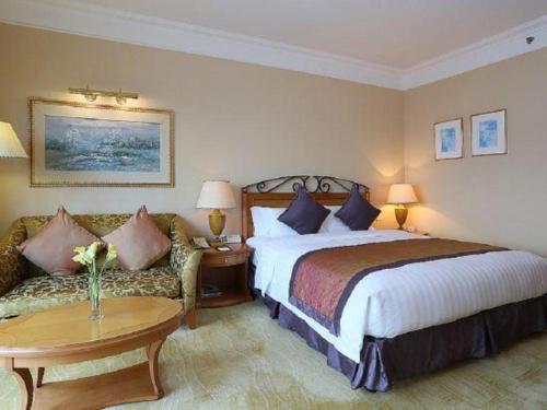 a hotel room with a bed and a couch at Regency Hotel in Shantou