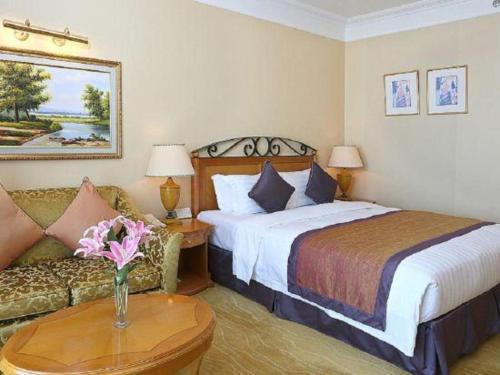 a hotel room with a bed and a couch at Regency Hotel in Shantou