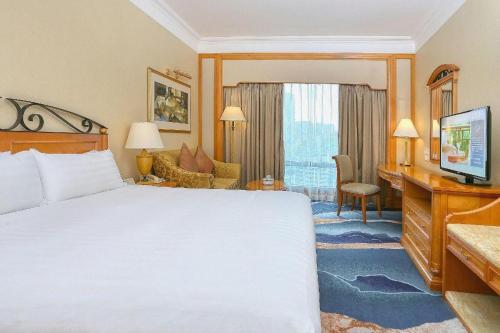 a hotel room with a bed and a desk at Regency Hotel in Shantou