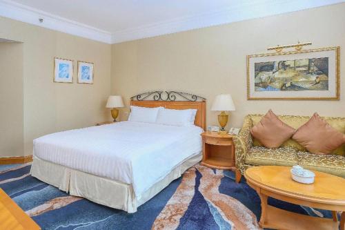 a bedroom with a bed and a couch at Regency Hotel in Shantou