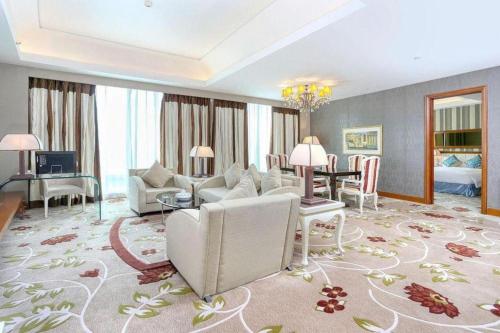 a living room with a couch and a dining room at Regency Hotel in Shantou
