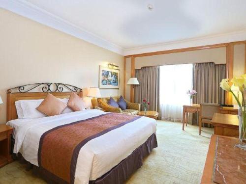 a hotel room with a large bed and a couch at Regency Hotel in Shantou