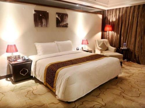 a hotel room with a large bed and a chair at SUN Yat-sen university Hotel and Conference Centre in Guangzhou