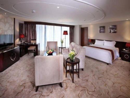 a large hotel room with a bed and a living room at SUN Yat-sen university Hotel and Conference Centre in Guangzhou